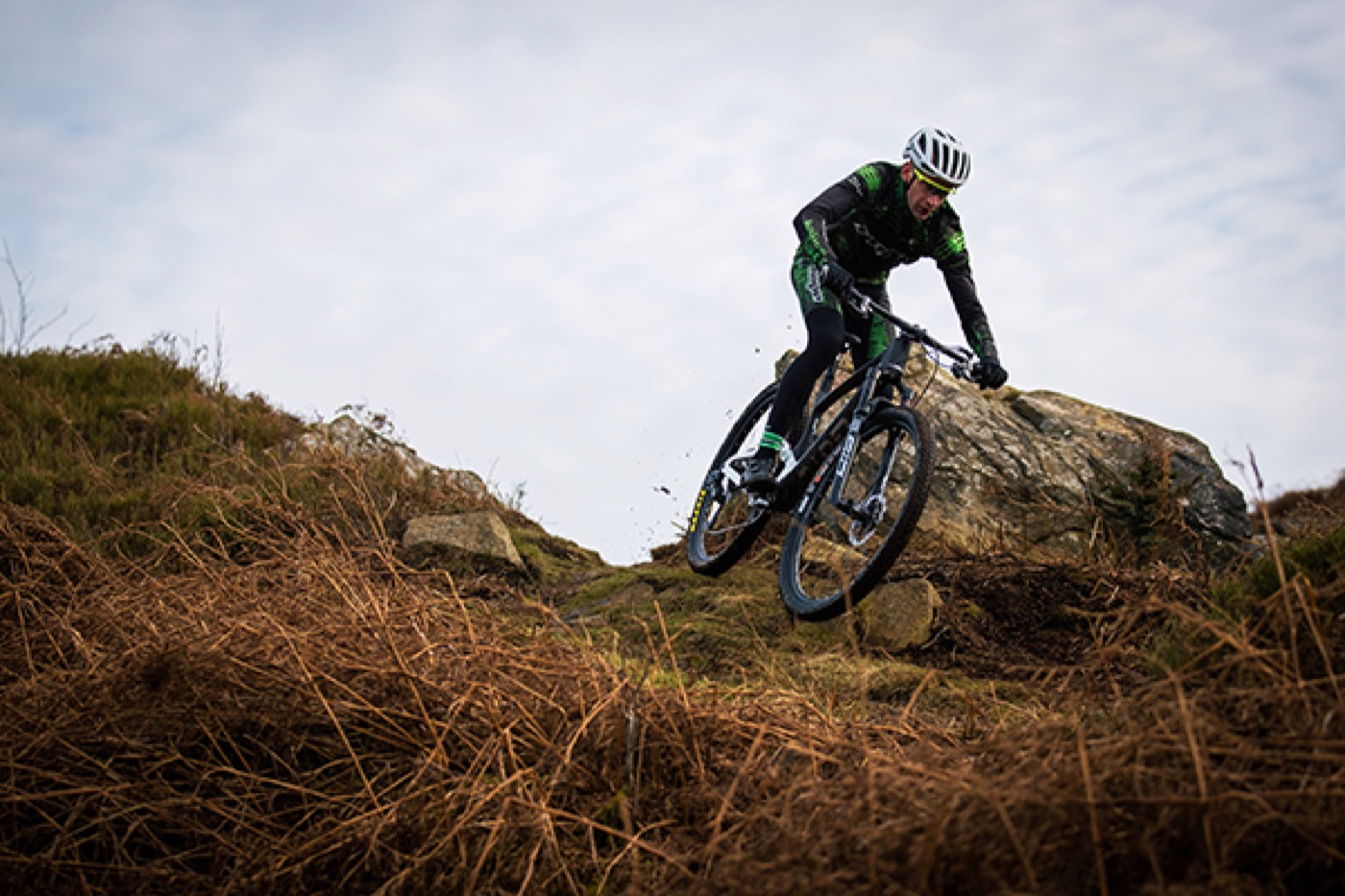 Rider descending rocky trail on a bike equipped for downcountry and trail riding